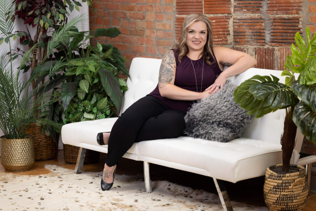 Female business owner sitting on a couch for her personal branding session at a photography studio in Bloomington, IL